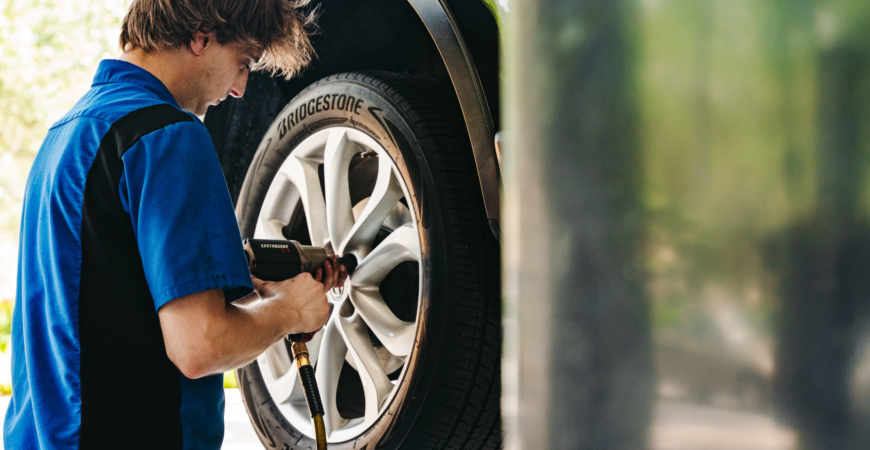 mechanic putting a tire back on after a proper alignment and balancing